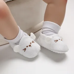 Detailansicht der weißen Baby-Lauflernschuhe mit süßem gesticktem Mausgesicht und Ohren.