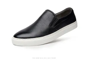 Close-up of black leather slip-on sneakers with textured grain and white sole