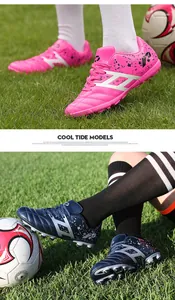 Detailed view of professional children's turf soccer shoes in vibrant pink and navy blue