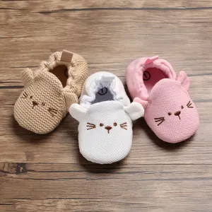 Nahaufnahme von drei gestrickten Babyschuhen mit süßem Katzenstickerei-Detail.