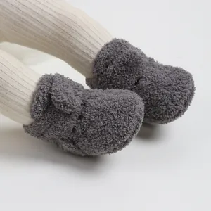 Vista dettagliata di morbidi stivaletti invernali in peluche grigio scuro per neonati