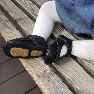 Close-up of black PU baby princess shoes with honeycomb soft sole and scallop edges