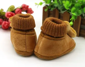 Detailed macro view of brown plush baby winter walking shoes with elastic ribbed cuffs