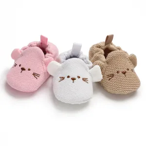 Detailansicht süßer gestrickter Baby-Lauflernschuhe mit Katzenstickerei in drei Farben