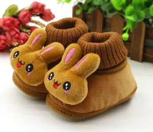 Detailed macro view of the 3D plush cartoon rabbit design on soft brown baby walking shoes