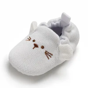 Detailansicht der weißen gestrickten Baby-Lauflernschuhe mit süßer Katzenstickerei.