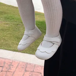 Close-up view of white PU baby Mary Jane shoes featuring delicate scalloped edge details