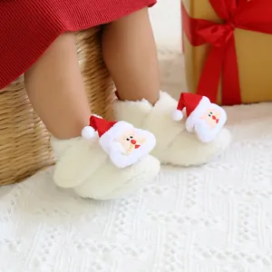 Nahaufnahme von gemütlichen Baby-Weihnachtshausschuhen mit Plüsch-Weihnachtsmann-Detail