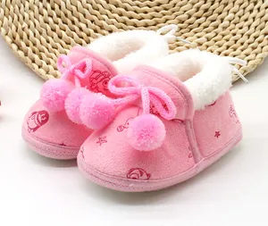Primo piano di stivaletti invernali rosa per neonati con fodera in peluche e pompon