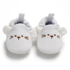 Detailansicht weißer Baby-Lauflernschuhe mit weicher Sohle und Tiermotiv-Stickerei.