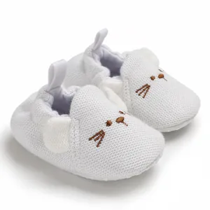Weiche Baby-Lauflernschuhe aus weißem Strick mit niedlicher Tier-Stickerei im Detail.