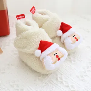 Nahaufnahme von weißen Plüsch-Babyschuhen mit festlicher Weihnachtsmann-Stickerei