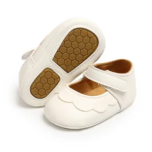 Close-up of white baby Mary Jane shoes with scalloped edges and non-slip honeycomb sole