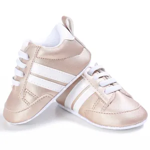 Detalle en primer plano de la textura suave de los zapatos de bebé en color oro rosa
