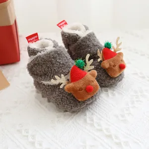 Detailaufnahme von grauen flauschigen Baby-Weihnachtsstiefeln mit Rentier-Dekoration