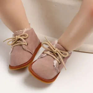 Nahaufnahme von warmen rosa Wildleder-Babyschuhen mit weichem Kunstfellfutter und Gummisohlen.
