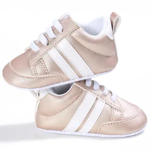 Primer plano de zapatillas metálicas para bebé con rayas blancas y suela blanda