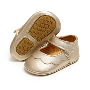 Detailed view of champagne gold baby Mary Janes with scalloped edges and non-slip soles