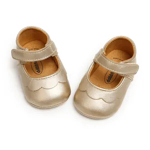 Detail of gold PU leather baby princess shoes with scalloped edges and Velcro strap.