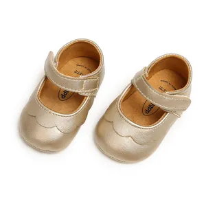 Detailed view of golden baby Mary Jane shoes with scalloped edges and Velcro straps