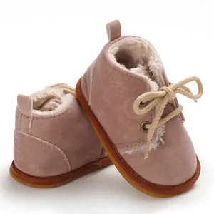 Nahaufnahme von rosa Babystiefeln mit warmem Kunstfellfutter und einer Gummisohle