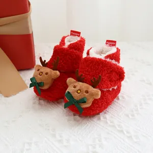 Detailaufnahme roter Fleece-Babystiefel für Weihnachten mit Rentier-Design und Schleife