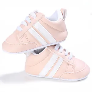 Vista detallada de zapatos rosa suaves para bebé con rayas blancas y cordones