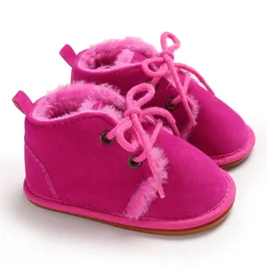 Detailansicht pinkfarbener flauschiger Baby-Lauflernschuhe mit Gummisohle und Schnürung.