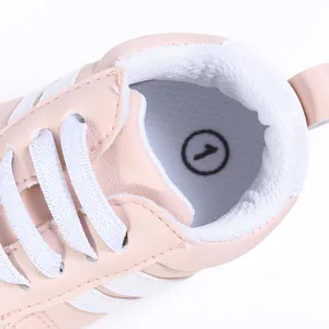 Primer plano detallado del interior del zapato de bebé rosa con forro suave y etiqueta de talla