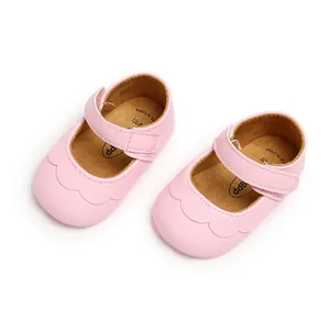 Close-up detail of pink baby Mary Jane shoes with scalloped edges and velcro strap