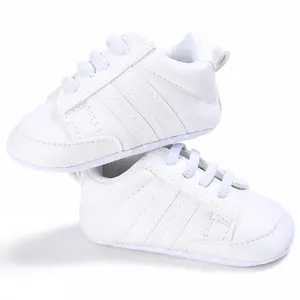 Vista detallada de zapatillas blancas para bebé con suela blanda y rayas decorativas