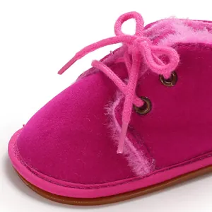Nahaufnahme der rosa Babyschuhe mit flauschigem Futter und weicher Wildleder-Materialtextur