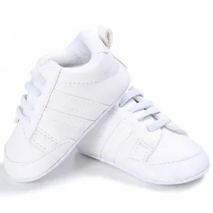 Primer plano de zapatillas blancas para bebé con suelas blandas y costuras