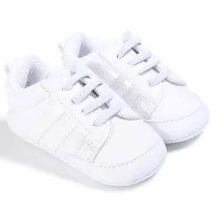 Detalle macro de zapatos blancos para bebés con suelas blandas y diseño de cordones