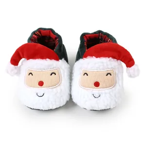Nahaufnahme von Baby-Weihnachtshausschuhen aus weichem Plüsch mit Stickereien.