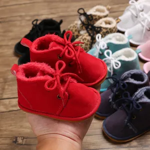 Detailaufnahme von roten, plüschgefütterten Baby-Lauflernstiefeln mit Gummisohlen