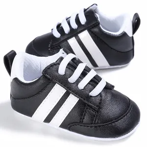 Vista detallada de zapatillas deportivas blancas y negras con suela blanda para bebés