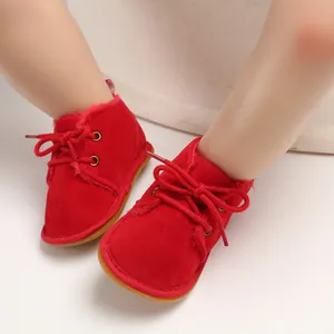 Nahaufnahme von roten Baby-Lauflernschuhen aus Wildleder mit warmem Futter und Schnürung