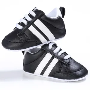 Vista detallada de los zapatos de marcha clásicos para bebés con rayas blancas y negras