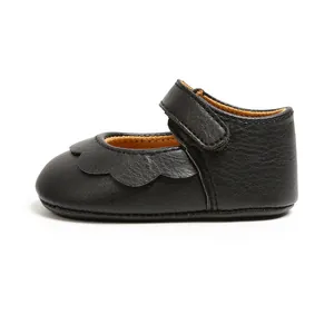 Detailed view of black PU leather baby princess shoes with scalloped edges and Velcro strap