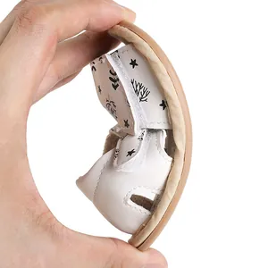 Close-up showing the flexible soft sole of a white baby sandal for infants and toddlers