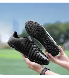 Dettaglio ravvicinato scarpe da calcio nere per bambini con suola in gomma resistente