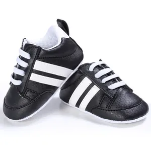 Primer plano de zapatos de marcha para bebés en blanco y negro con suela muy blanda.