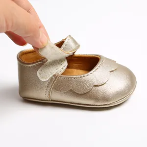 Close-up of champagne gold baby Mary Jane shoe with hook-and-loop strap detail