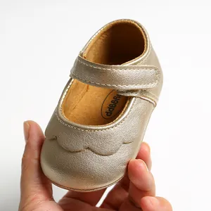 Macro view of golden PU soft sole infant baby walker shoes with scalloped design