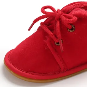 Detailaufnahme eines roten Babylernschuhs aus weichem Wildleder mit Schnürung und Futter.
