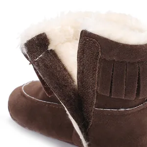 Close-up of warm faux fur lining and fringe on brown baby winter snow boots