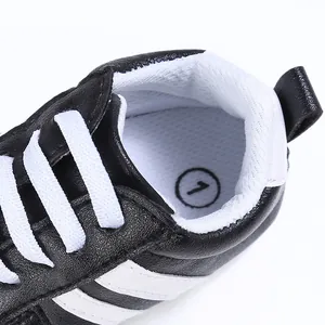 Imagen detallada de zapatos deportivos para bebés en blanco y negro con suela blanda
