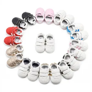 Collection of colorful baby walking shoes with velcro straps arranged in a heart shape
