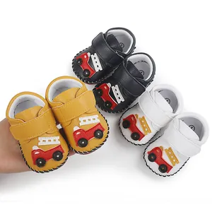 Détail de chaussures de marche pour bébé multicolores avec applique camion pompier.